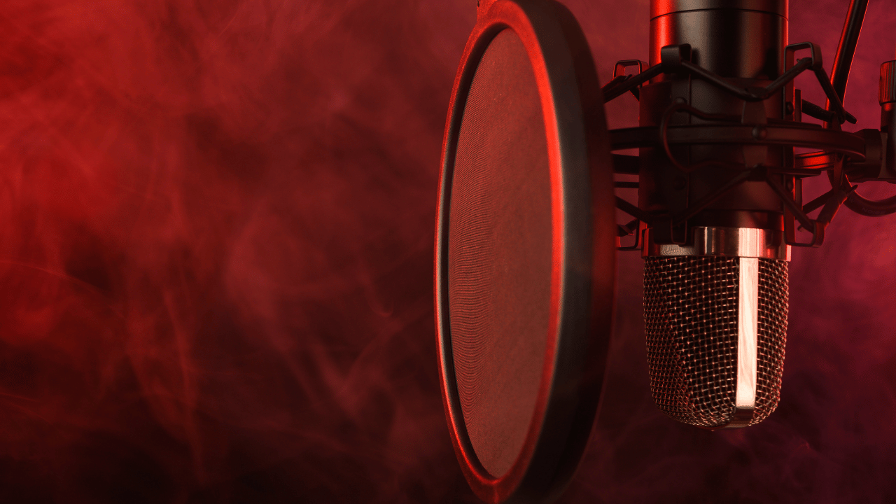 Vocal microphone and pop filter set up in a recording studio with red light