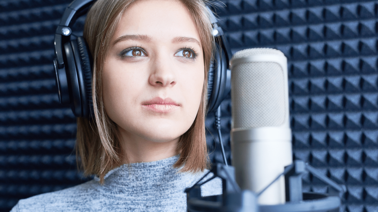 a singer-songwriter with headphones in a vocal booth getting ready to record