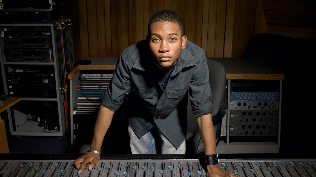 Electronic music producer mixing a beat on an SSL mixing console